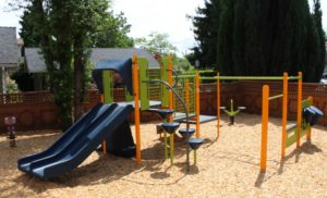 blue and green playground on woodchip surfacing