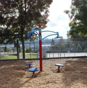 blue and red playground on woodchip surfacing