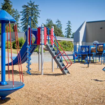 red and blue school playground on woodchips