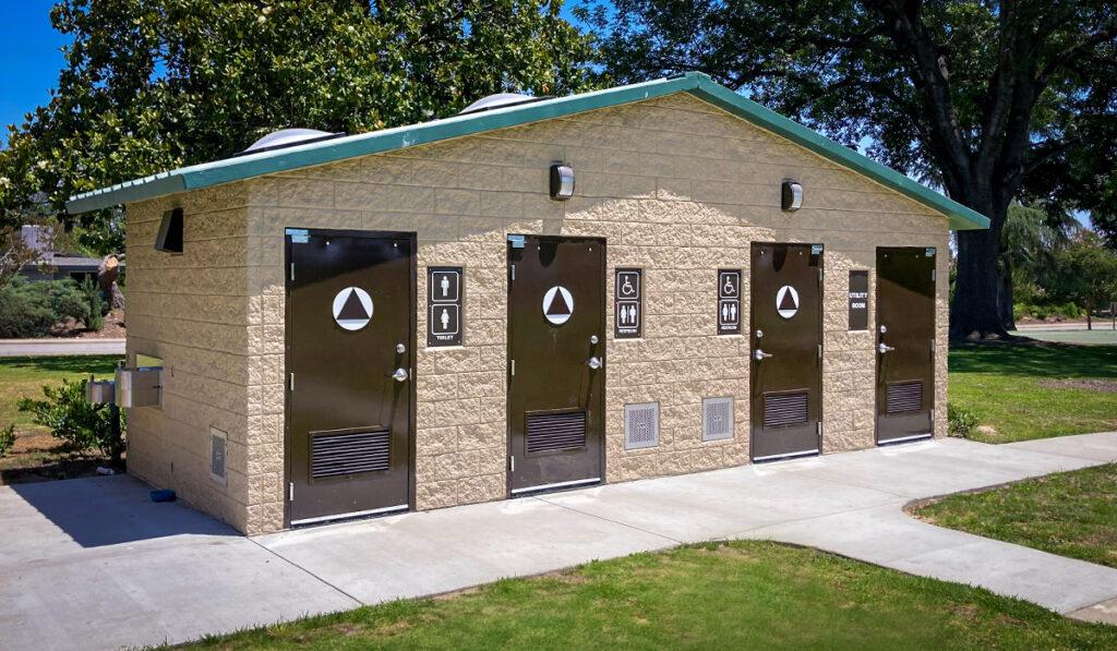 washroom building with stone lower walls, barnwood upper walls with ribbed metal roof