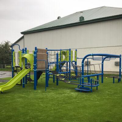 Green, blue, brown and black playground on artificial grass surfacing