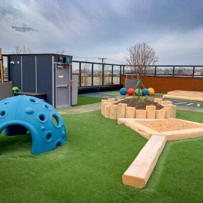 blue cozy dome and habitat systems natural play custom playspace with engineered wood fibre (EWF), artificial grass and pour-in-place (PIP) rubber surfacing