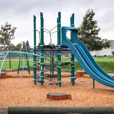 blue and green playground on engineered wood fibre (EWF) surfacing