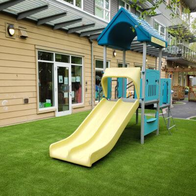 blue, yellow play structure on artificial grass surfacing