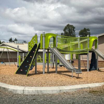 green, blue and silver playground on engineered wood fibre (EWF) surfacing